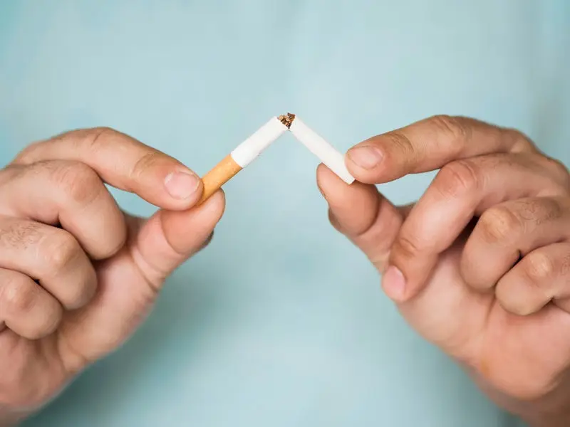 Tobacco Abuse and Addiction: man breaking a cigarette